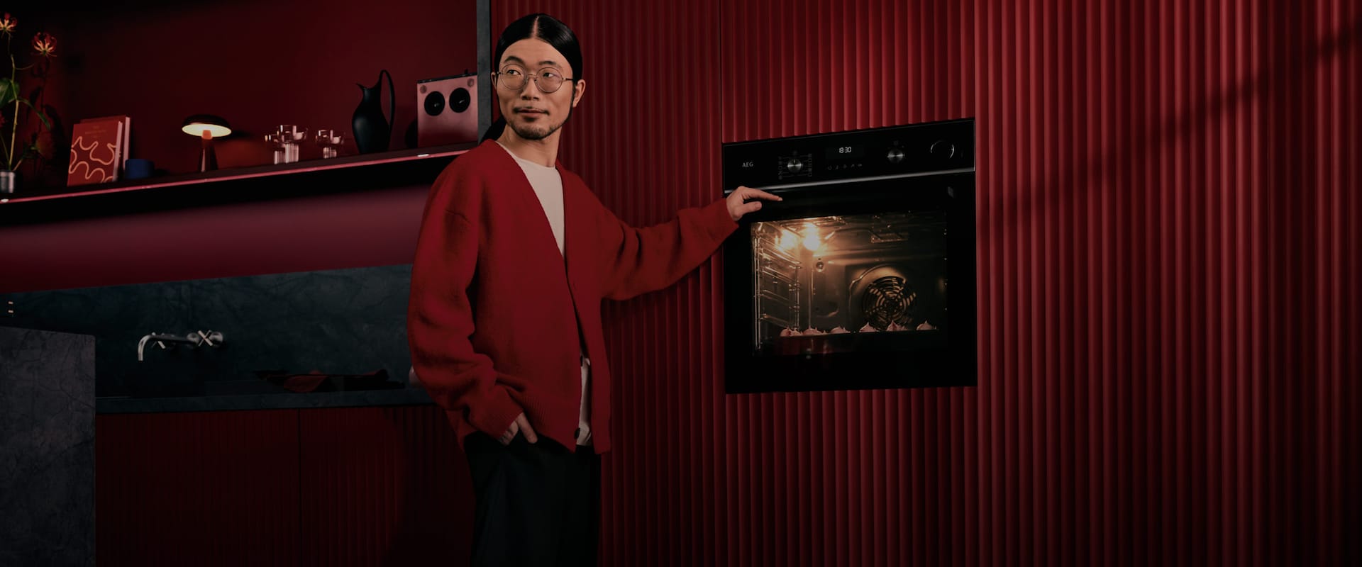 Nuori mies seisoo AEG:n kalusteisiin sijoitettavan uunin vieressä.